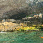Vista dalla canoa della costa rocciosa di Pizzo con una pagaia arancione in primo piano