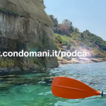 pagaia arancione a bordo di un kayak con scogliera e mare limpido