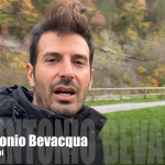 Relatore in primo piano con grafica inferiore sovrapposta e sfondo autunnale