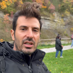 Relatore in primo piano che illustra i contenuti del corso con sfondo di alberi e colori autunnali.