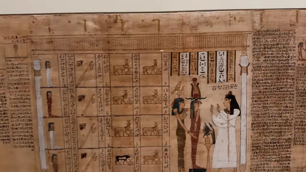 Primo piano di un frammento di papiro con colonne di geroglifici e figure egizie, nitido e ben definito