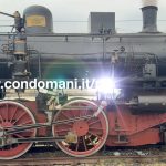dettaglio di una locomotiva storica con ruote e meccanica in primo piano