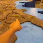 mano che indica la mappa in miniatura dell'italia esposta al museo